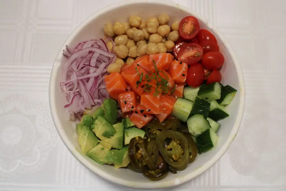 Salmon poke bowl with avocado, chickpeas, jalapeño and fresh veggies