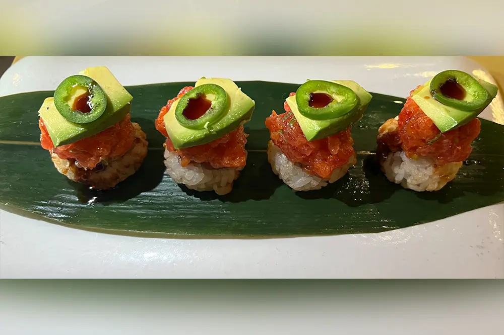 Spicy tuna crispy sushi bites topped with avocado and jalapeño